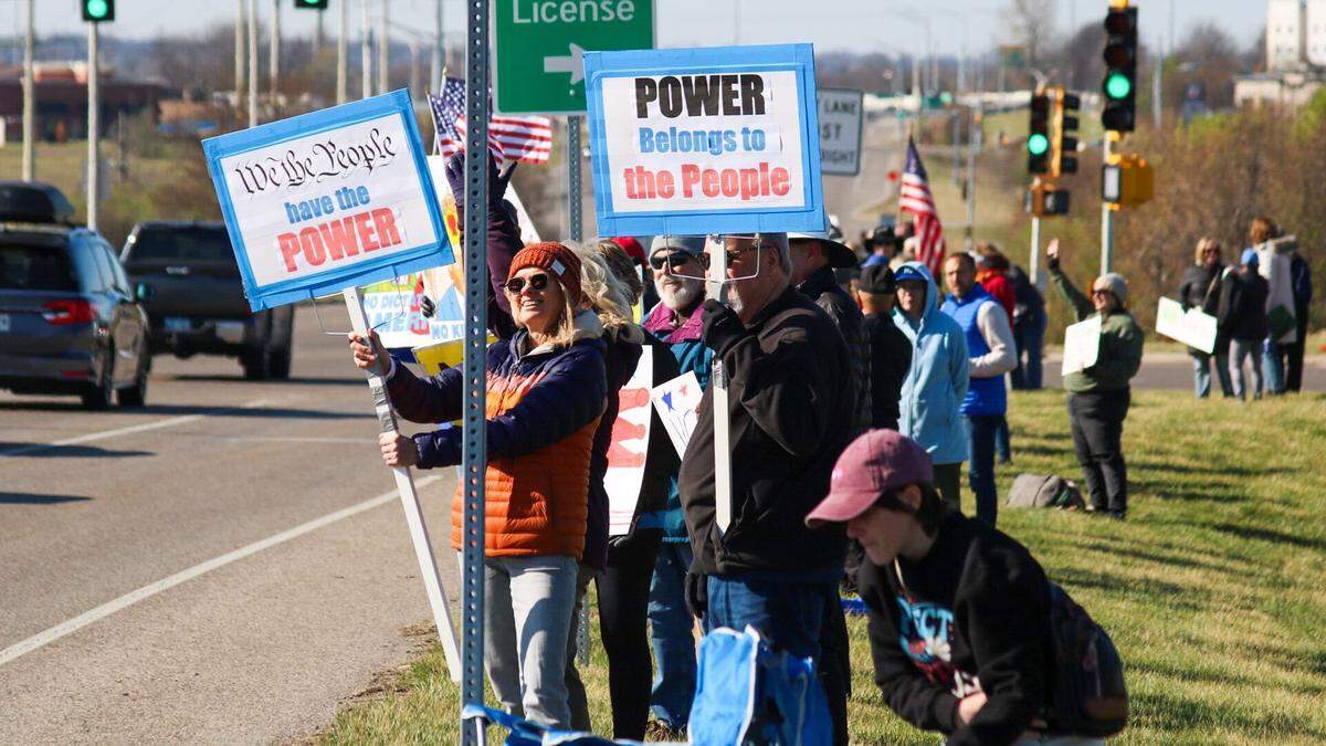 Carol Barlau, 66, holds a sign that reads “We the people have the power” at the No Kings rally in Overland Park on March 28, 2026.
