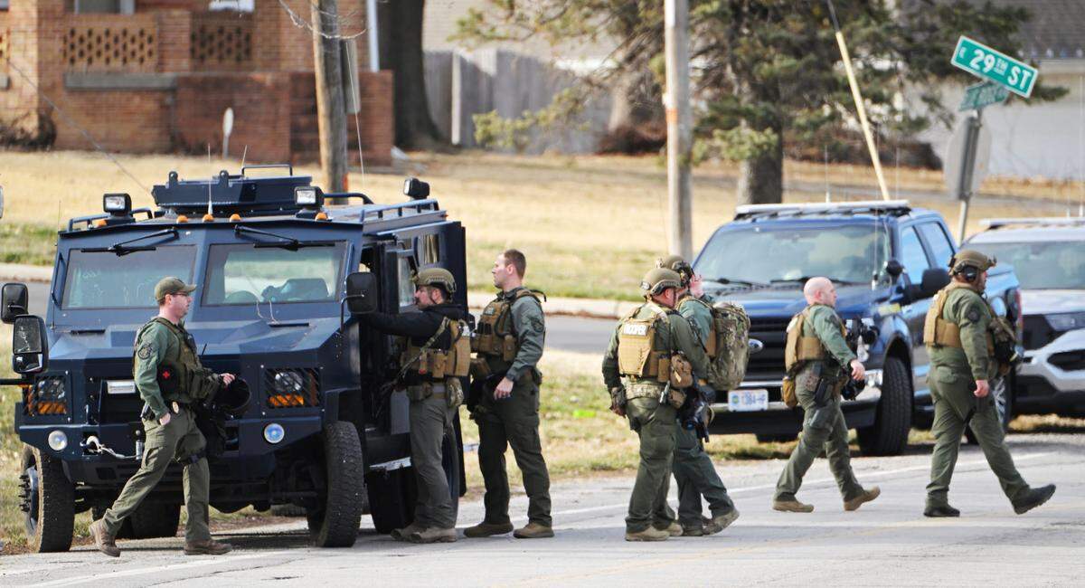 Members of the Missouri State Highway Patrol tactical team return to their vehicles after a suspect was taken into custody Wednesday during a standoff at a residence near 23rd Street and Blue Ridge Boulevard where three KCPD officers were shot Tuesday night.