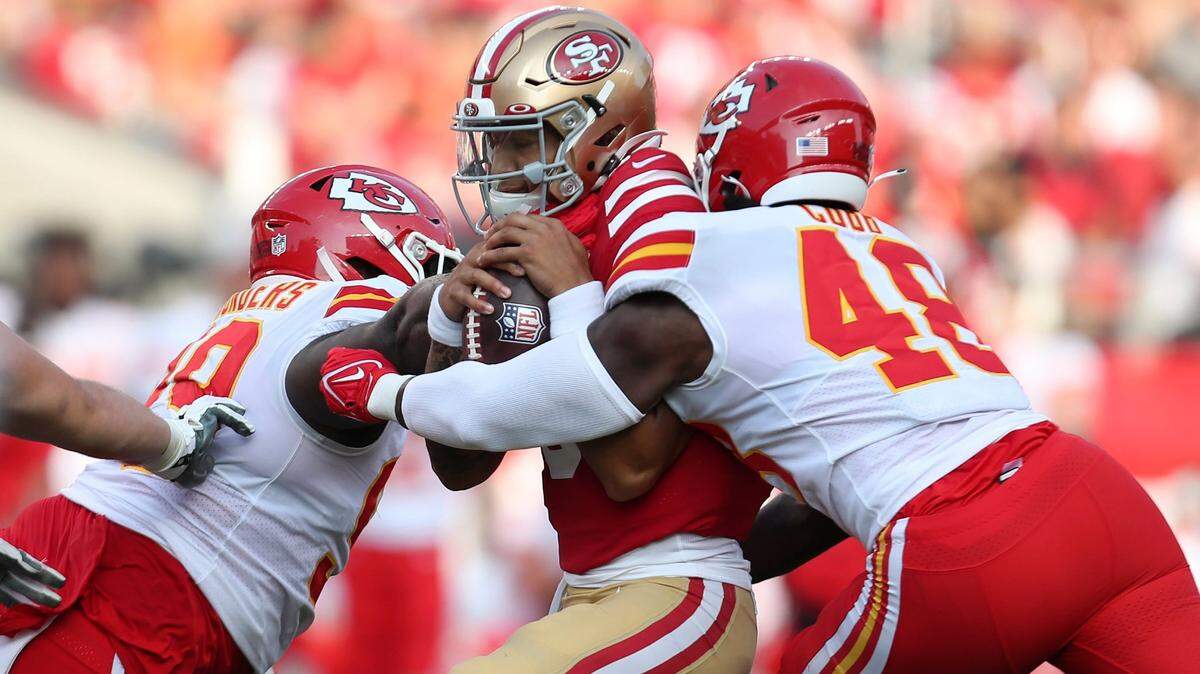 Chiefs defensive tackle Khalen Saunders, left, and linebacker Omari Cobb bring down San Francisco 49ers quarterback Trey Lance Saturday evening in Santa Clara, Calif.