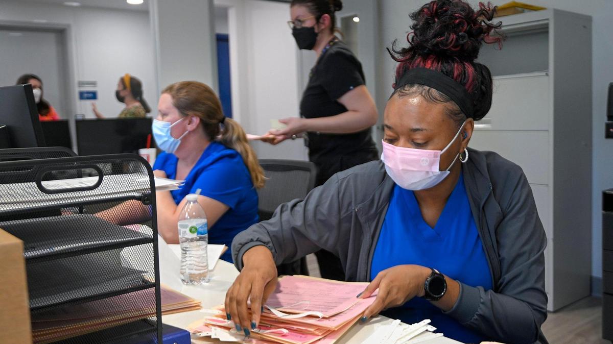 Priscilla Jones, left, and Janisha Lopez work at the reception desk of the Planned Parenthood clinic in Kansas City, Kansas. The health center is getting more requests for abortion services than it can handle.