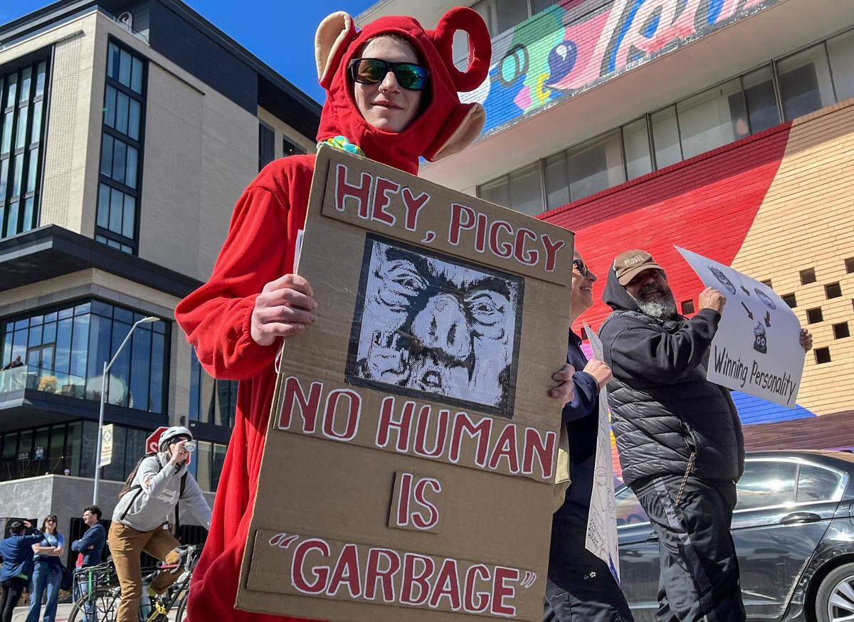 A protester holds up a sign while marching along Broadway Boulevard in Kansas City on Saturday, March 28, 2026, during a No Kings protest against the Trump administration.