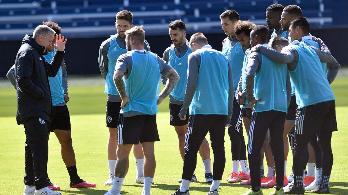 Sporting Kansas City coach Peter Vermes, left, talks to a group of his players during a workout at Children’s Mercy Park in Kansas City, Kan.