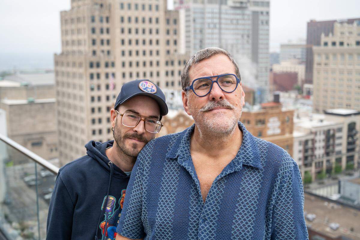 Kris Saim with his husband, Anthony, outside their home on Friday, April 10, in Kansas City. Saim has Stage 4 terminal cancer and is recording a podcast, Dying Out Loud, that talks about death. Saim's husband helped spur the idea of recording about the subject, and is also a producer on the podcast.
