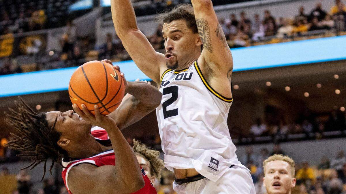Missouri’s Tre Gomillion, right, tries to block the shot of Southern Indiana’s Tyler Henry during Monday night’s opener for the Tigers at Mizzou Arena in Columbia, Mo.