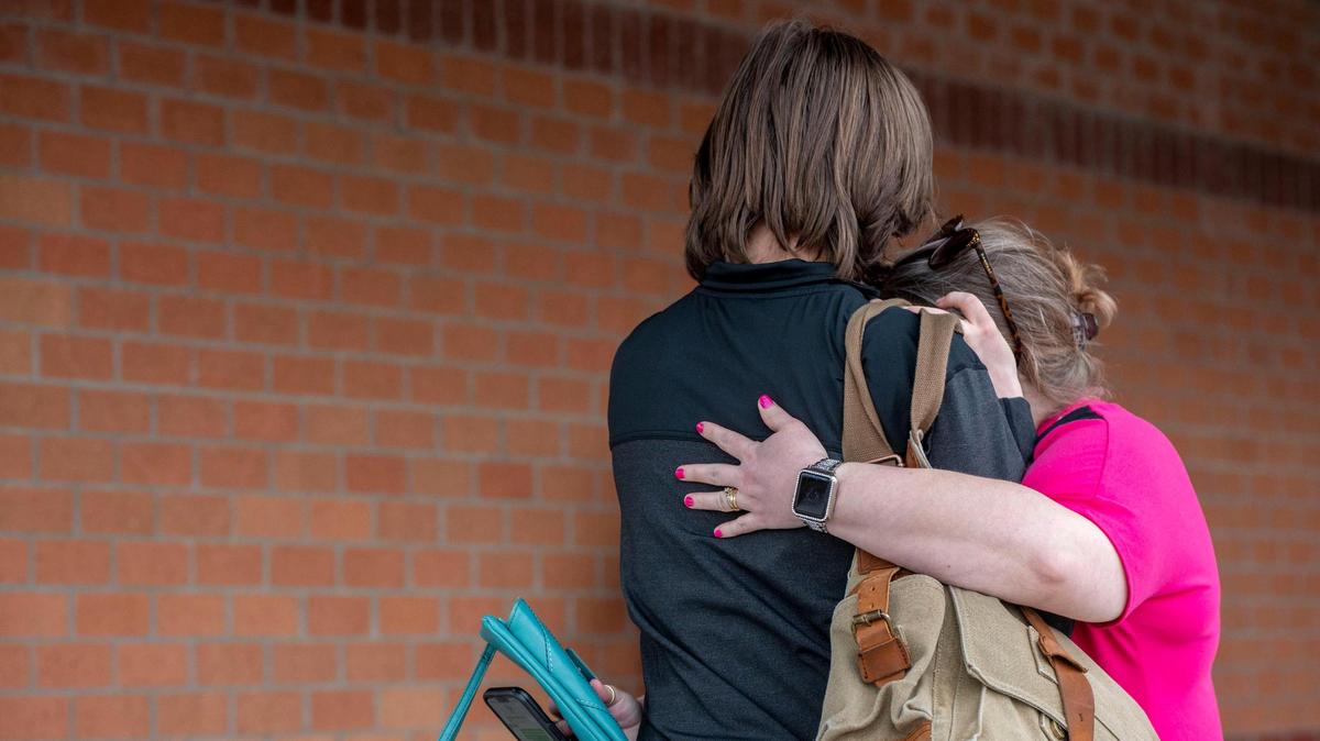 A parent hugs her child outside a Kansas school in 2022.