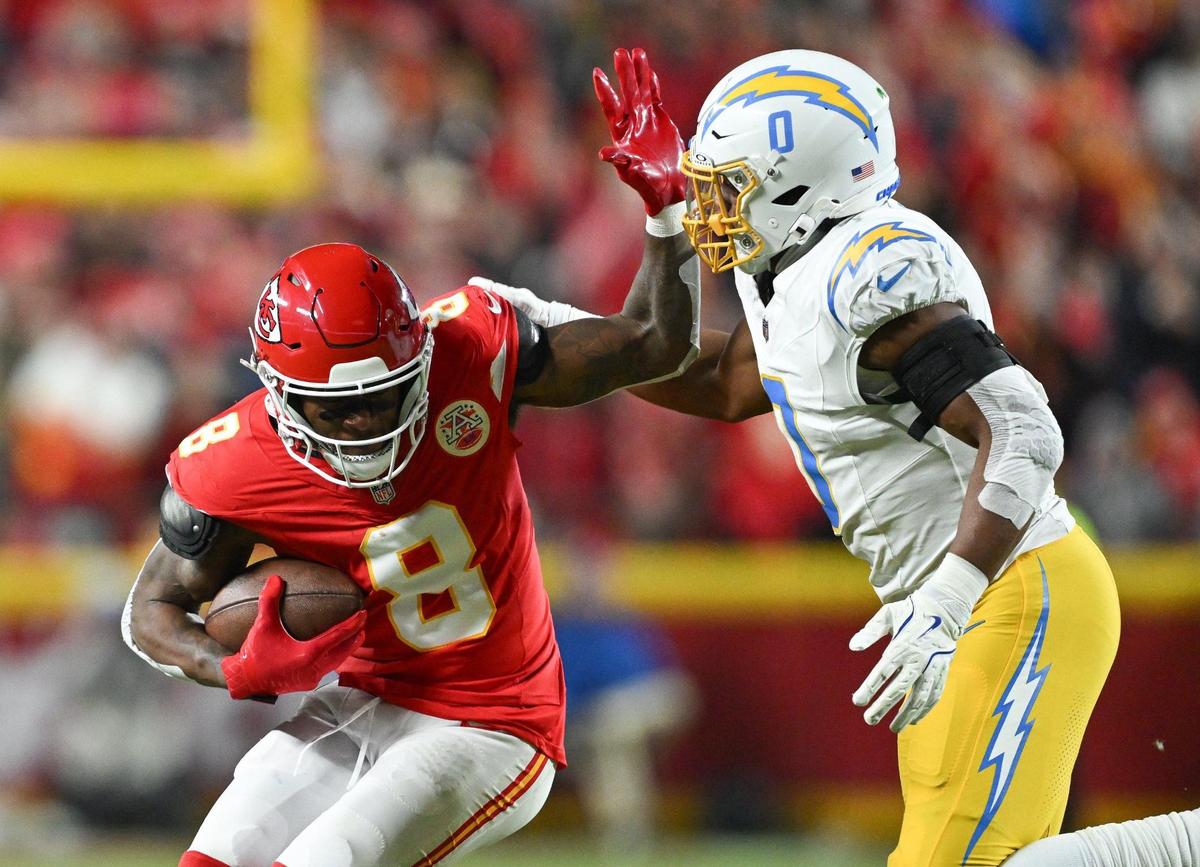 Kansas City Chiefs wide receiver DeAndre Hopkins (8) fends off Los Angeles Chargers linebacker Daiyan Henley (0) after making a reception in the second quarter on Sunday, Dec. 8, 2024, at GEHA Field at Arrowhead Stadium.