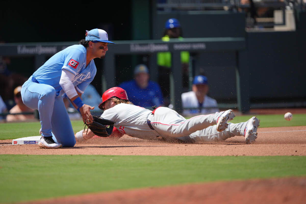 Philadelphia Phillies infielder Bryson Stott slides into third for a triple past Kansas City Royals third baseman Josh Rojas in the fifth inning at Kauffman Stadium on July 05, 2026 in Kansas City, Missouri.