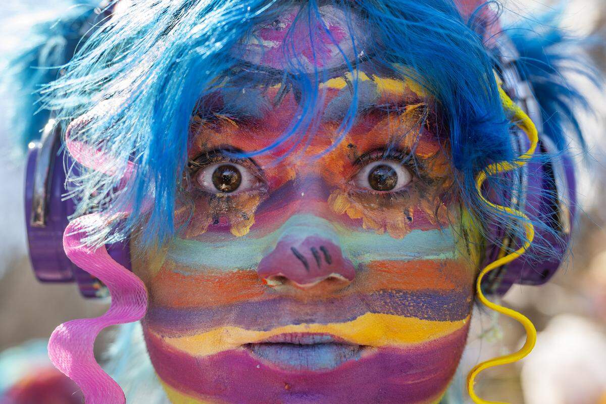 Ollie Clark, adorned in colorful face paint, stands for a portrait during the Krewe de Prank parade on Sunday, March 2, 2025, in Kansas City.