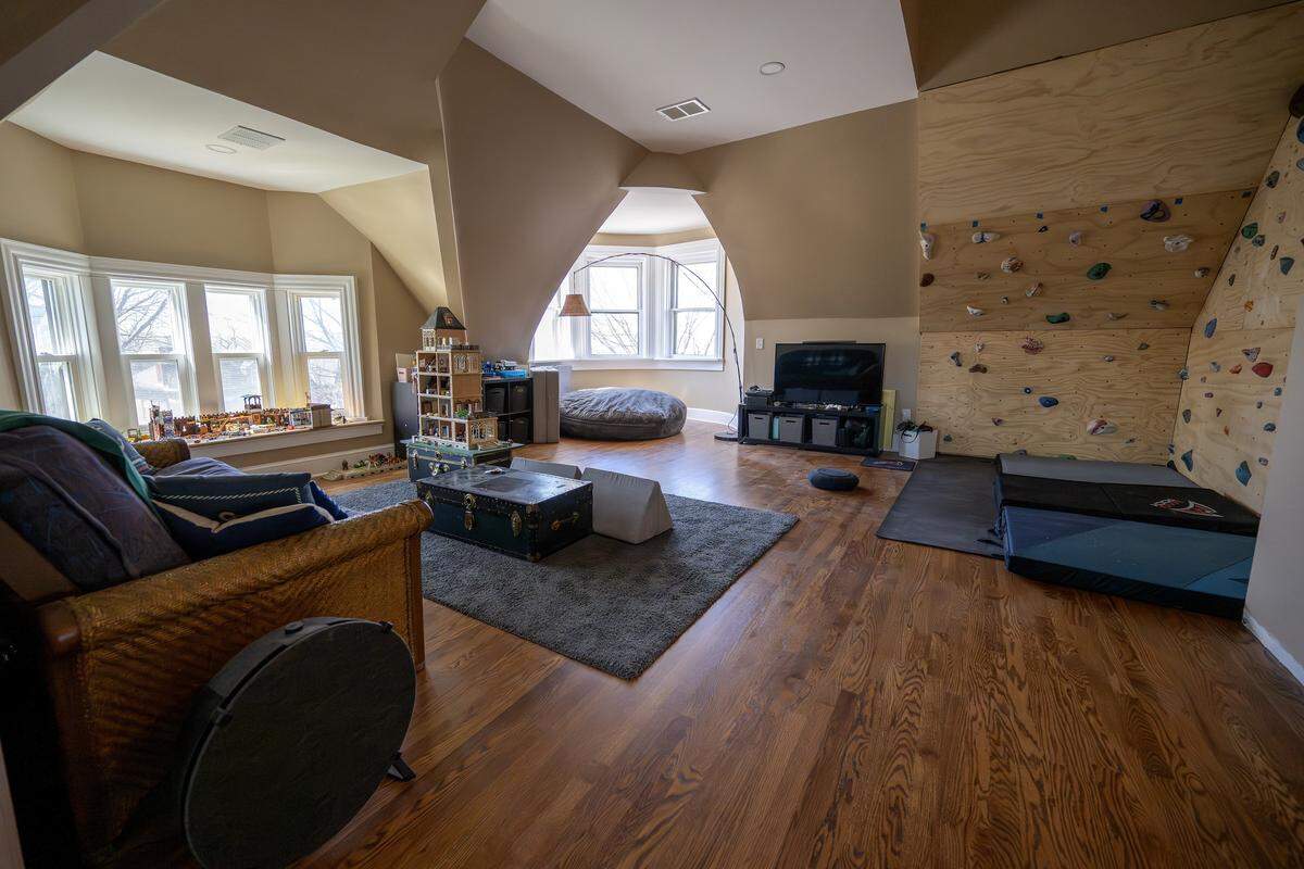 A family room with a seating area, toys and a rock climbing wall is seen in the upstairs area of the Bezanson family home on Wednesday, April 8, 2026, in Kansas City.