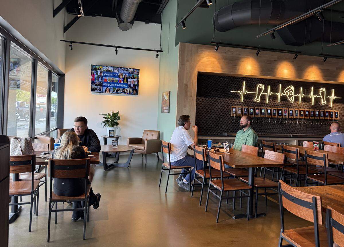 Customers sit near a self-pour tap wall at Smokin’ Oak.