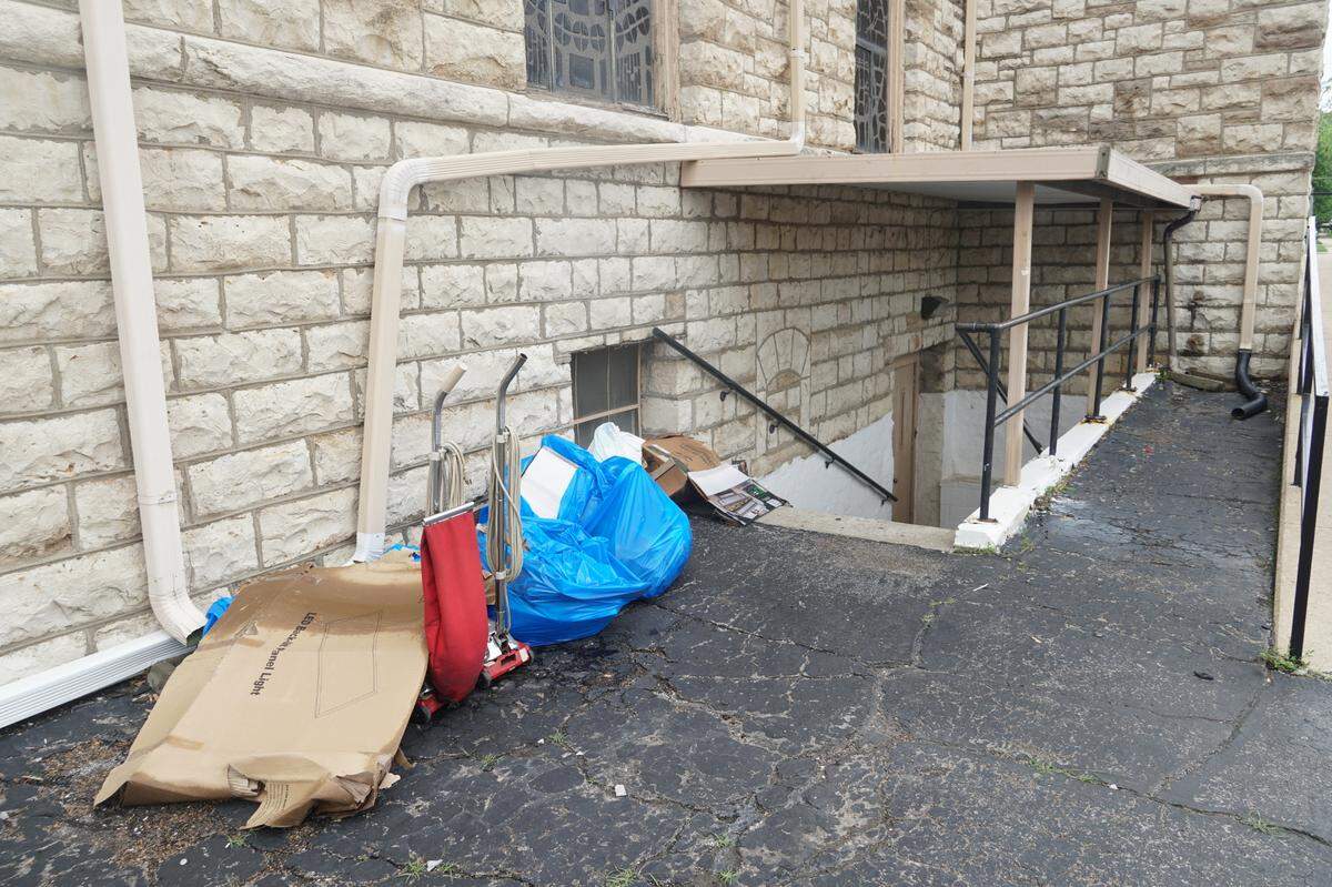 Water-damaged supplies stand outside the basement entrance of the St. John the Evangelist Church, San Juan Evangelista, off Strong Avenue in Kansas City, Kansas, on May 20, 2025. The church was among numerous buildings in the city’s Argentine neighborhood to experience flooding after heavy rain the previous evening.