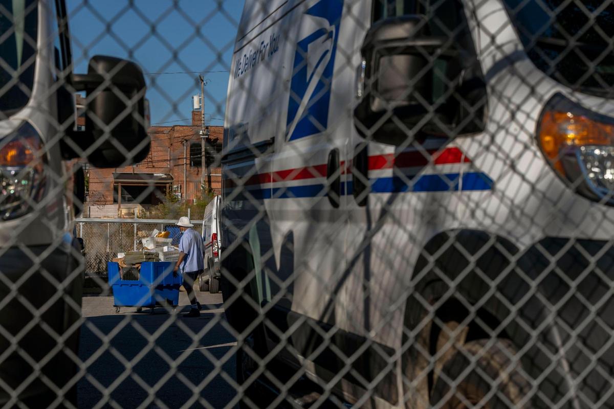 A postal service worker moves mail at a Kansas City area post office.
