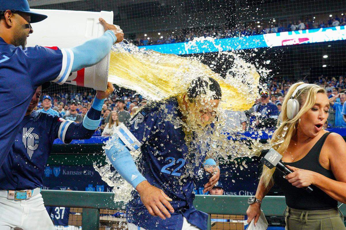 Kansas City Royals left fielder Tommy Pham (22) and Apple TV+ reporter Tricia Whitaker are doused by shortstop Bobby Witt Jr. (7) and designated hitter MJ Melendez (1) after the win over the Minnesota Twins at Kauffman Stadium on Sep 6, 2024 in Kansas City, Missouri, USA.