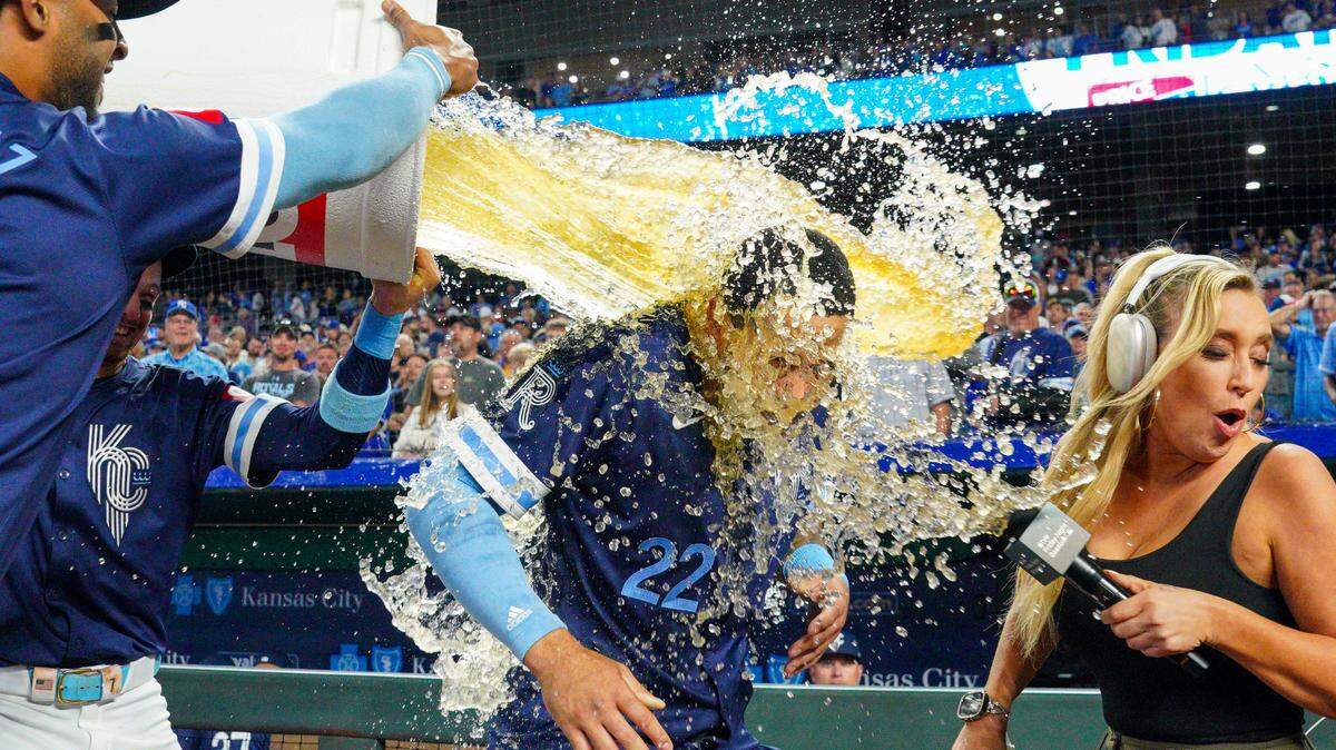 Kansas City Royals left fielder Tommy Pham (22) and Apple TV+ reporter Tricia Whitaker are doused by shortstop Bobby Witt Jr. (7) and designated hitter MJ Melendez (1) after the win over the Minnesota Twins at Kauffman Stadium on Sept. 6, 2024.