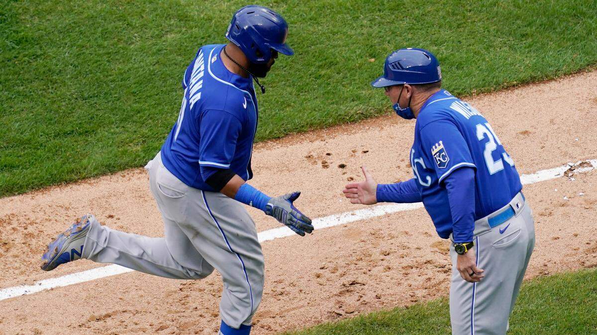 Kansas City Royals’ Carlos Santana, left, rounds the bases as he celebrates with third base coach Vance Wilson after hitting a solo home run during the ninth inning of a baseball game against the Chicago White Sox in Chicago, Sunday, April 11, 2021. (AP Photo/Nam Y. Huh)
