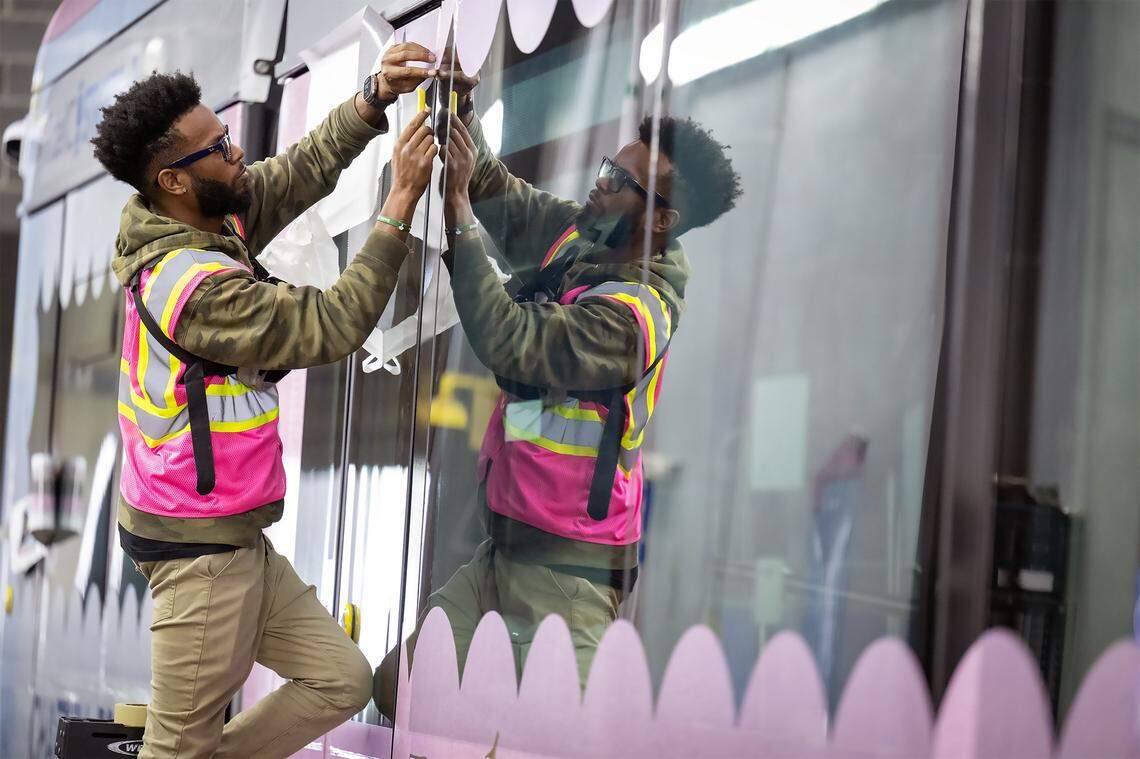 James Holmes IV attaches a vinyl decal to a KC Streetcar that was being wrapped in a Chappell Roan design on Thursday, Sept. 25, 2025, in Kansas City. The  singer, who paid for the wrap, will perform two concerts in October in Kansas City. 