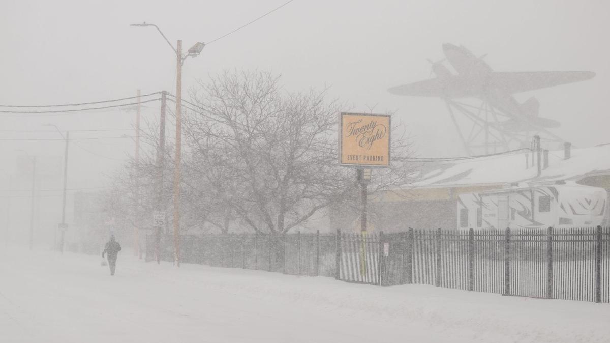 A person walks near the Roasterie Coffee shop during heavy snowfall on Sunday. Kansas City saw over five inches of snow fall in a matter of hours on Sunday, Jan. 5, 2025. Travel routes were heavily impacted with some people opting to travel by foot.