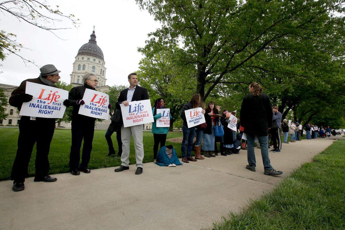 Former Kansas Secretary of State Kris Kobach, third from left, stands with about 100 pro-life supporters across the street from the Kansas Supreme Court building Thursday, May 9, 2019, in Topeka, Kan. The group was protesting an recent ruling by the court stating that the Kansas Constitution protects a woman’s right to an abortion. (AP Photo/Charlie Riedel)