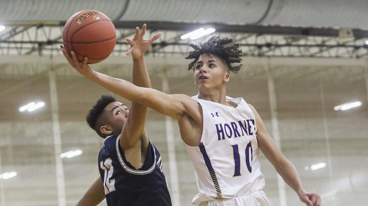 North Kansas City junior guard Malik Johnson (right) went in for the layup through the outstretched arms of Lee’s Summit West forward Tysen Brennan during the William Jewell Holiday Classic game on Friday December 27, 2019 at William Jewell College in Liberty.