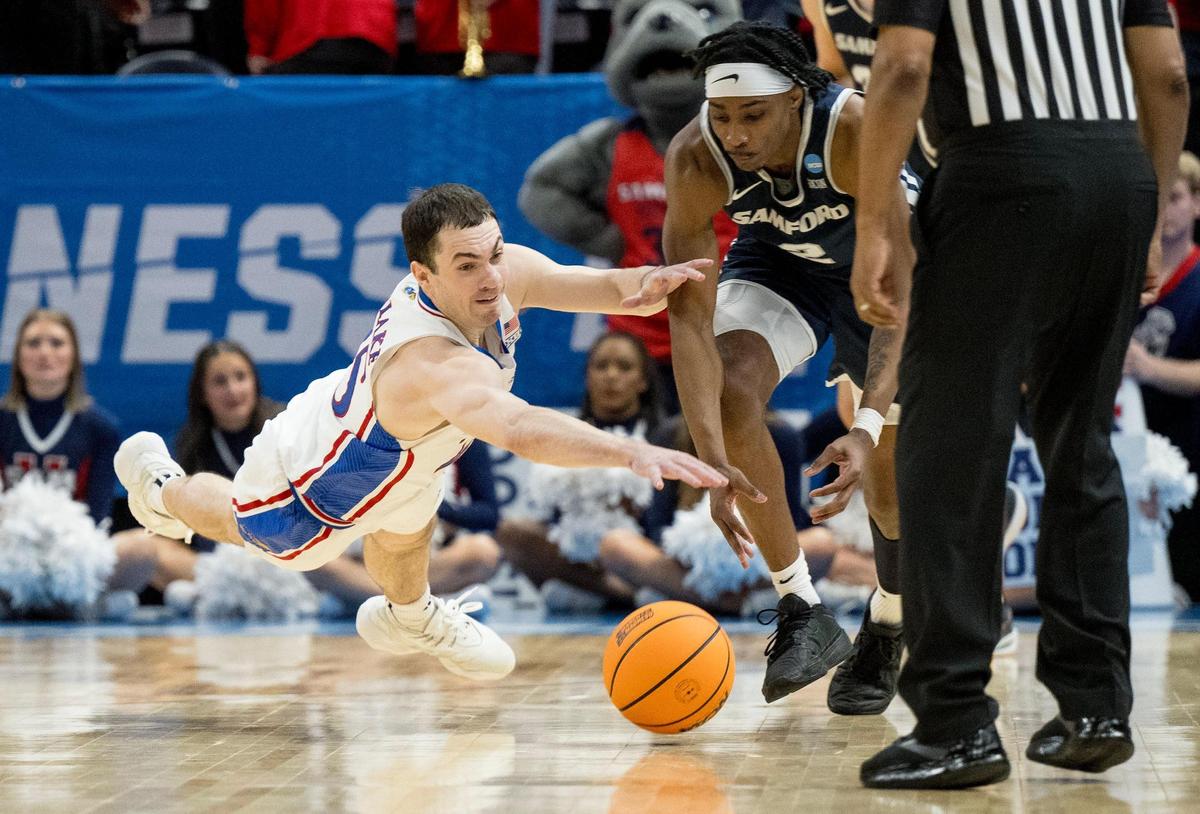 Kansas Jayhawks guard Nicolas Timberlake (25) and Samford Bulldogs guard Jaden Campbell (2) compete for a loose ball during a men’s college basketball game in the first round of the NCAA Tournament on Thursday, March 21, 2024, in Salt Lake City, Utah.