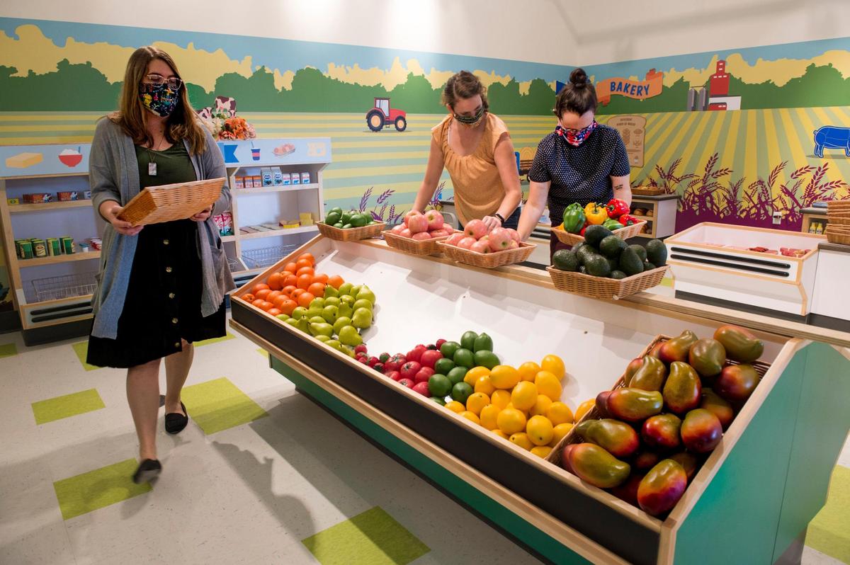 Employees set up the Wonder Market exhibit for the grand opening.