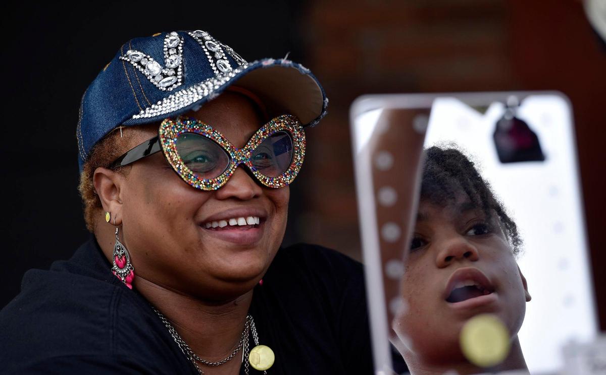 Sharlie Nelson, owner of VIP Luxary Chic talks with 13-year-old Skye Dyer of Kansas City, Kansas, who was interested in a jewelry item at Nelson’s booth during the first Pride on the Vine 2021 at the 18th and Vine Jazz District Saturday, June 26, 2021. Nelson said she identifies as an ally of the LGBTQ community.