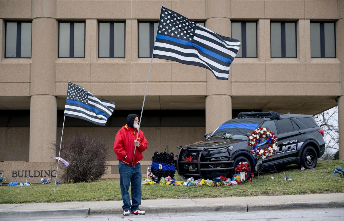 Norvin Johnson holds a thin blue line flag while waiting for the funeral procession of Independence police officer Cody Allen on Friday, March 8, 2024, in Independence. Allen was fatally shot during an eviction in northeast Independence last week.