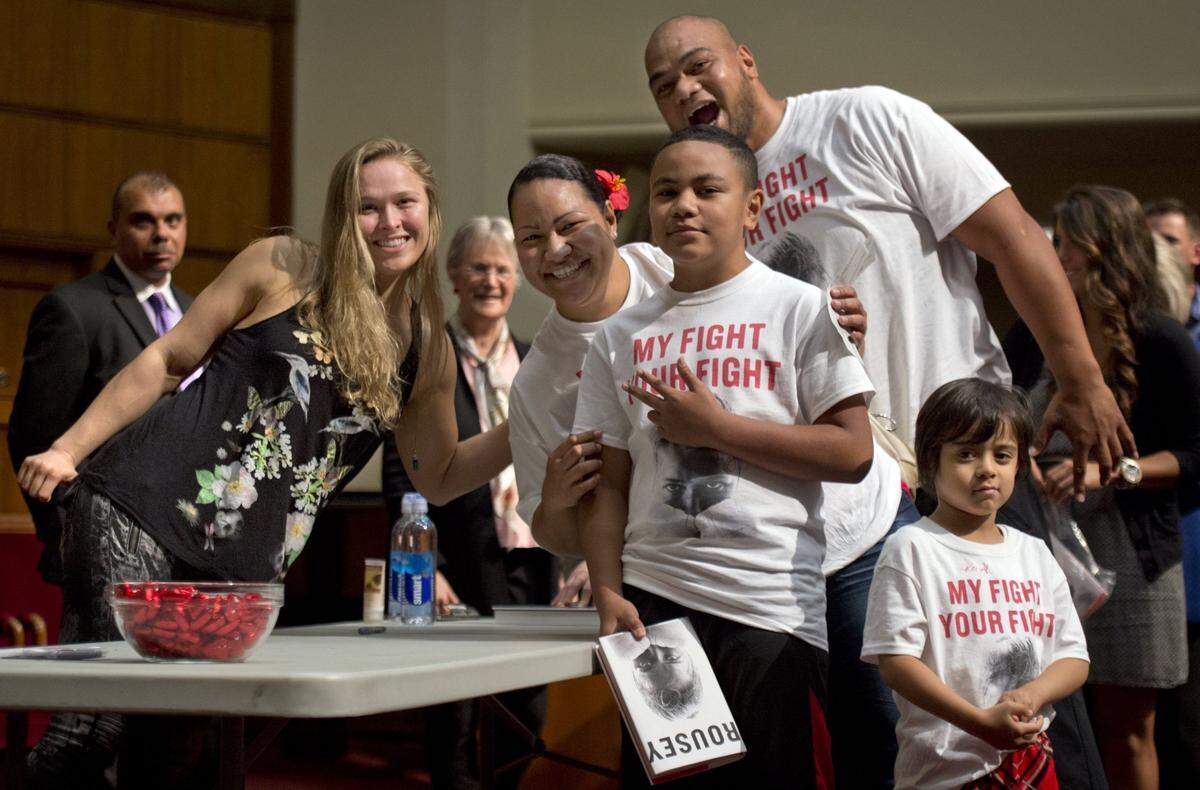 Junior, his sister Rezetta, his nephew Sao and son Michael pose with mixed-martial-arts fighter Ronda Rousey at a 2015 book signing at Unity Temple on the Plaza.