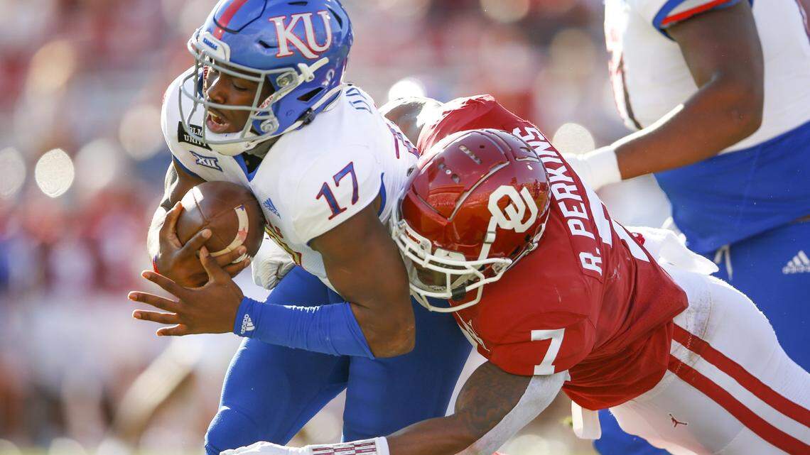 Kansas quarterback Jalon Daniels was brought down by Oklahoma defensive end Ronnie Perkins in Norman, Okla., on Saturday, Nov. 7, 2020.