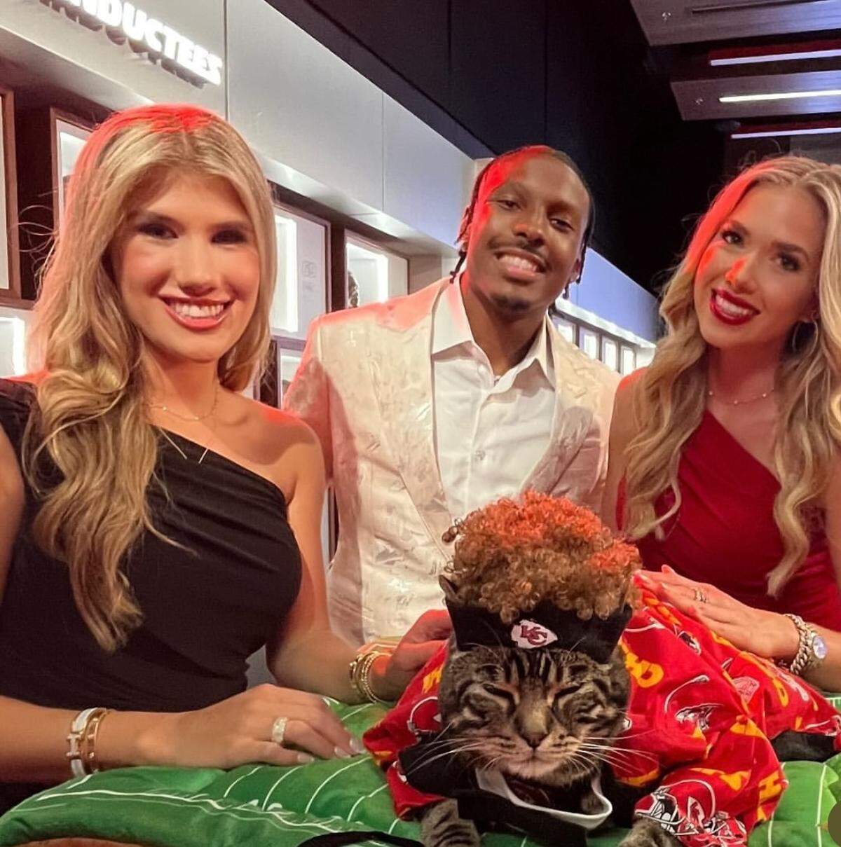 From left, Ava Hunt, Mecole Hardman and Gracie Hunt, with Sly James the Cat, on the set of “Holiday Touchdown: A Chiefs Love Story,” in July.
