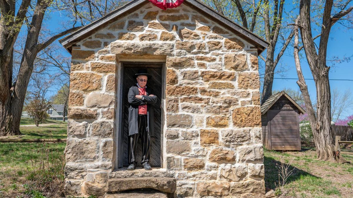 Paul Bahnmaier, president of the Territorial Capitol Museum, wears a sheriff’s costume while giving a tour of a one-room jail house in Lecompton, Kansas.