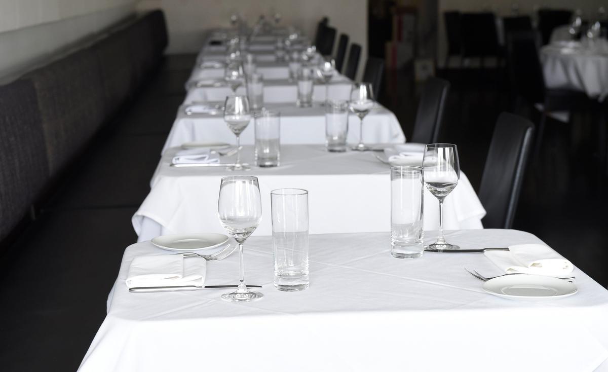 The tables are set, but Story restaurant in Prairie Village is dark because of the coronavirus pandemic. The restaurant is making food for carryout orders only.