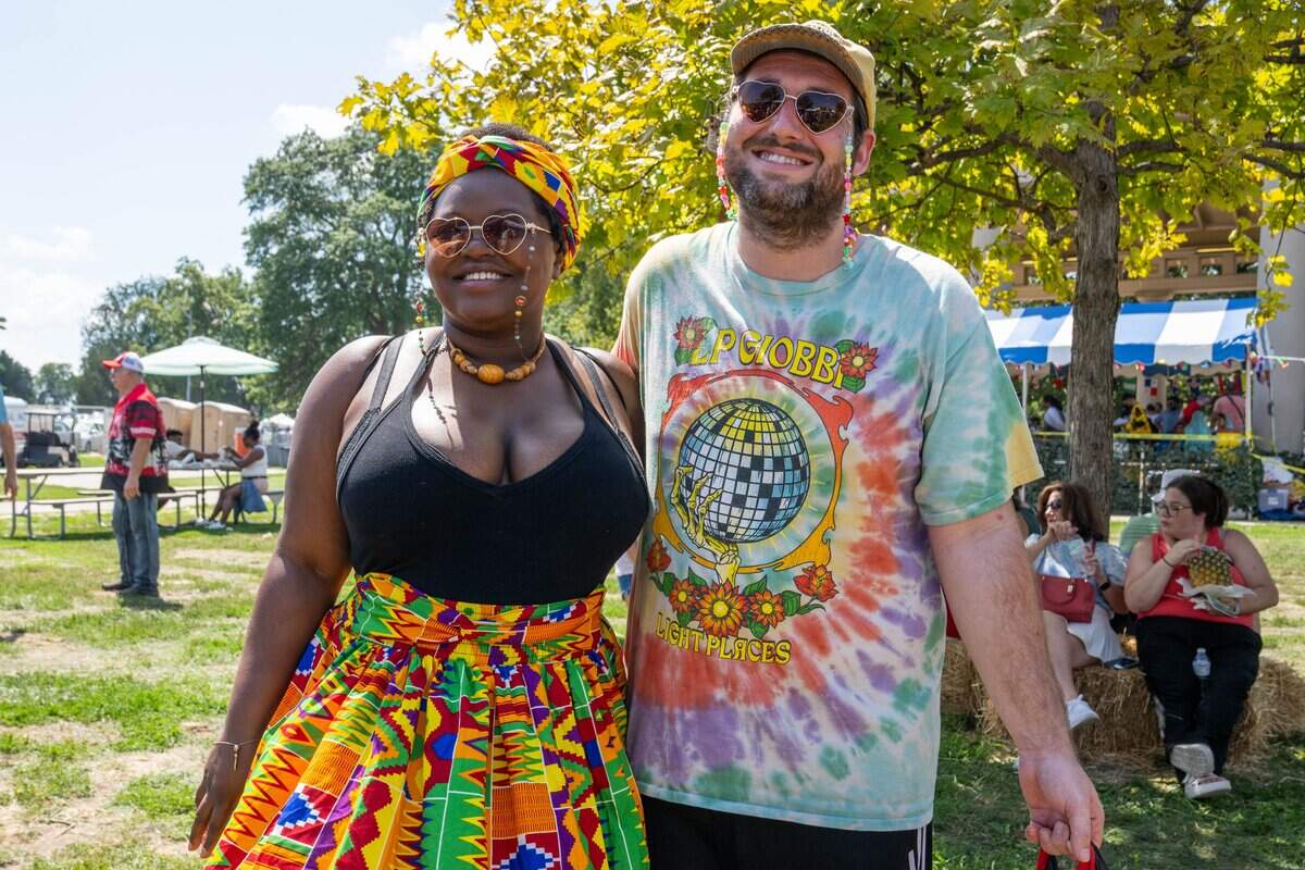 Shawnise Whitelow and Willis Kessler stand in line for Samoan food at the Ethnic Enrichment Festival in Swope Park on Saturday, Aug. 16, 2025, in Kansas City. Kessler and Whitelow both attend the festival every year and bring Tupperware so they can save some food for leftovers.