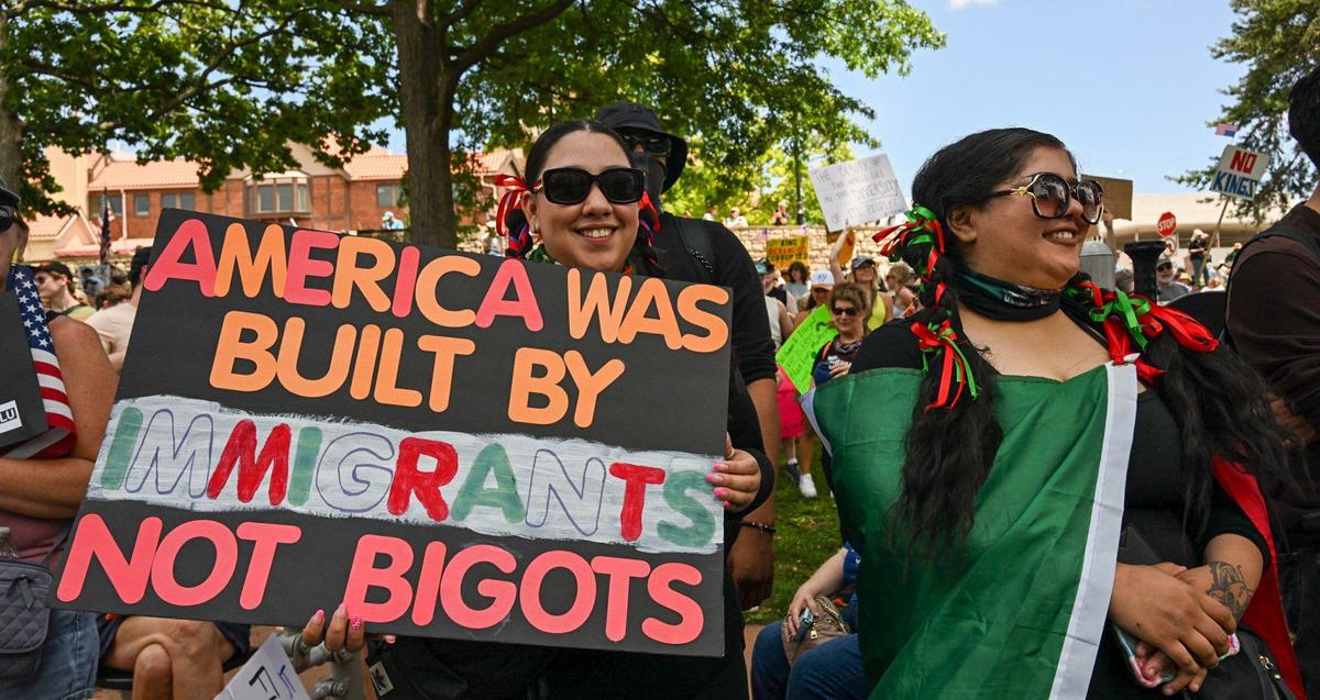 The Trump administration’s policies on immigration were the subject of many signs during the “No Kings” rally Saturday, June 14, 2025, at Mill Creek Park in Kansas City.