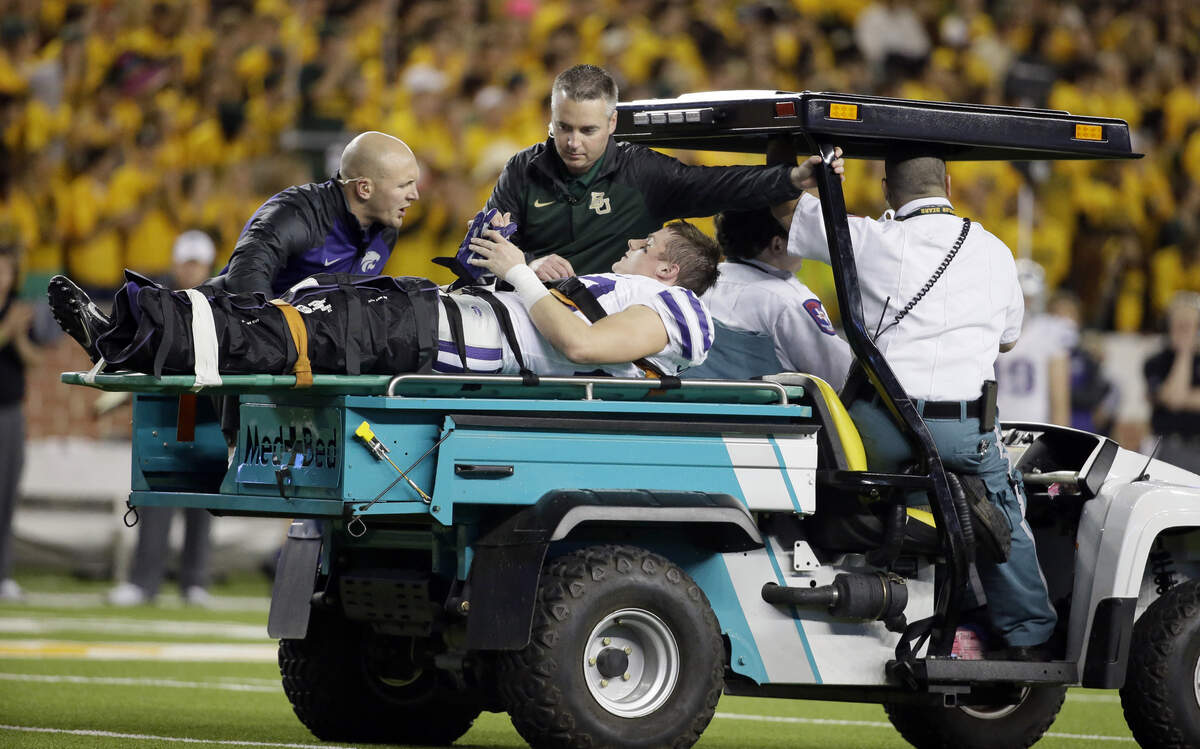 Kansas State defensive back Dylan Schellenberg (20) is carted off the field by medical personnel after suffering an injury to his left leg during the first half of an NCAA college football game against Baylor, Saturday, Dec. 6, 2014, in Waco, Texas. 