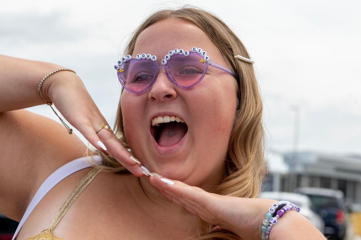 Katie Pittman poses for a photo wearing heart-shaped sunglasses while waiting in line at Taylor Swift’s Eras Tour stop at GEHA Field at Arrowhead Stadium on Friday, July 7, 2023, in Kansas City.
