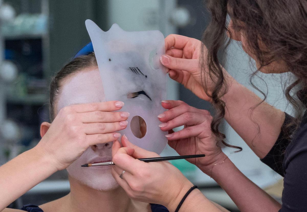 Makeup artist Katie Wasicko uses a template to reproduce an exact copy of makeup on several of the dancers appearing in “The Nutcracker.”