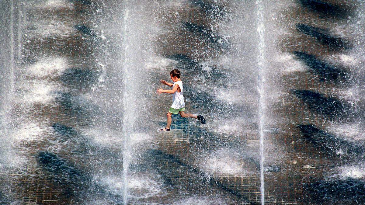 A lad races through the jets of the Crown Center Square Fountain. The fountain employs 49 jets of water that each squirt 25 feet in the air, unless there’s a stiff wind. (When it’s windy, a computerized sensor lowers the spray.) Pumps at this fountain circulate 4,000 gallons of water per minute.