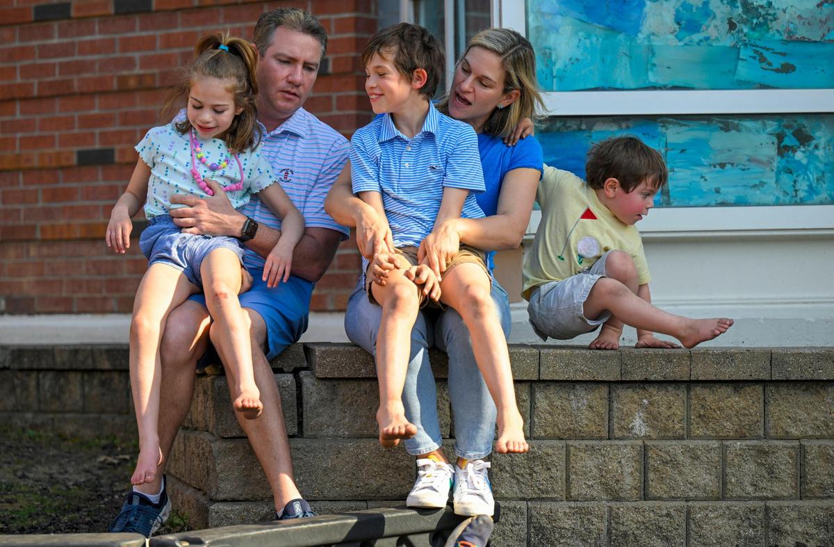 Michael and Melissa Foster of Mission Hills sit with their children, Hattie Foster, 6, from left, Charlie, 9, and Will, 3, during a visit Sunday, April 2, 2023, to the playground at Prairie Elementary School in Prairie Village. Hattie has SYNGAP1, a neurological disorder, which her parents said includes intellectual disabilities, gastro issues, autism, sleep issues, aggression, gait issues and epilepsy. The parents make a point to visit parks and playgrounds during off-times because Hattie may become aggressive toward other children.