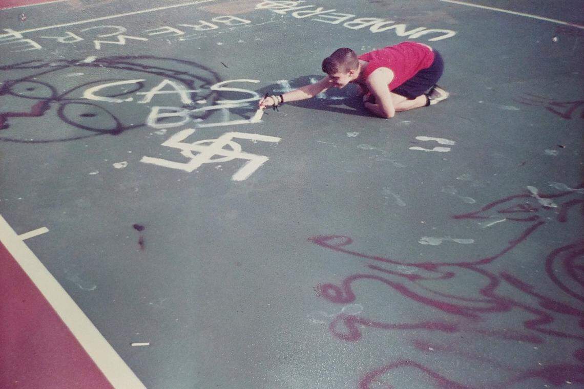A young Shannon Foley Martinez tags a swastika and other white supremacist symbols on a tennis court. Foley Martinez says she became indoctrinated into white supremacy at the age of 15 as a means of coping with lingering trauma and feelings of loneliness.