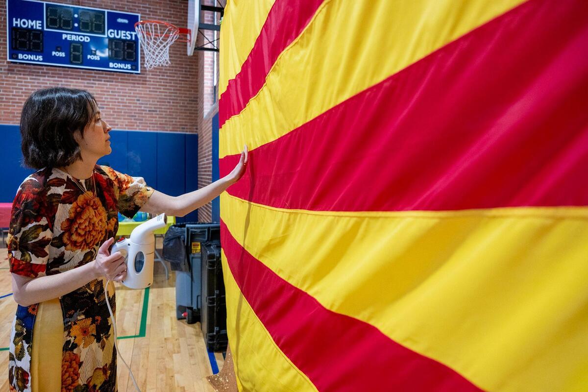 Lauri Pham smooths a wrinkle from a flag of South Vietnam.