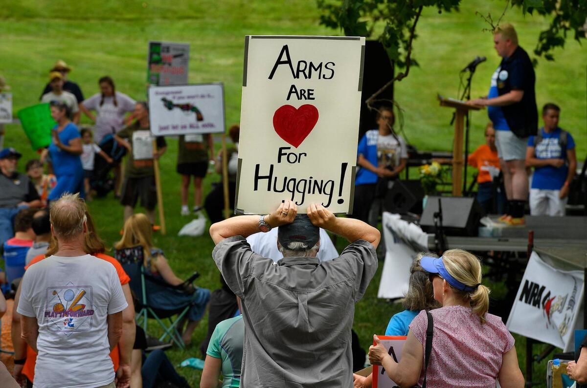While LBGTQ community activist Jae Moyer, right rear, spoke to a crowd of about 350 people at Saturday’s March for Our Lives rally at Gillham Park, a spectator held up a sign denouncing the proliferation of assault weapons that are being used in mass shootings throughout the United States. Angered by the unrelenting toll from gun violence, tens of thousands of people are expected at rallies this weekend in the nation’s capital and around the United States demanding that Congress pass meaningful changes to gun laws.