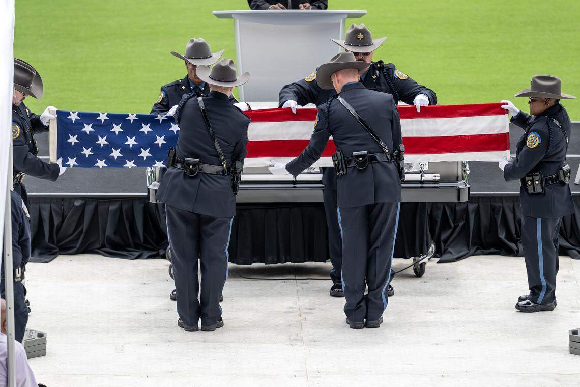 First responders fold the U.S. flag from Deputy Elijah Ming's coffin during the flag presentation ceremony held at Children's Mercy Park on Monday, Aug. 11, 2025, in Kansas City, Kansas.