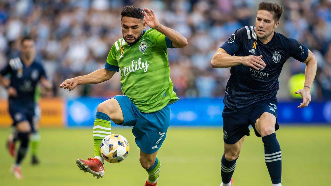 Seattle Sounders midfielder Cristian Roldan corrals the ball as Sporting KC’s Andreu Fontas defends during the first half of Sunday night’s game in Kansas City, Kan.