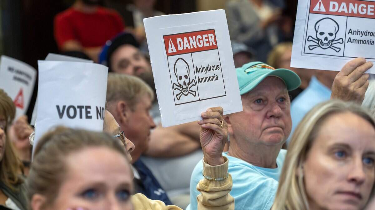 Residents hold signs opposing a proposed Lineage Cold Storage facility during the Olathe City Council meeting on Tuesday, Sept. 16, 2025, at Olathe City Hall. The facility is planned near 175th Street and Lone Elm Road, where nearby residents have raised concerns about traffic, environmental and safety impacts.