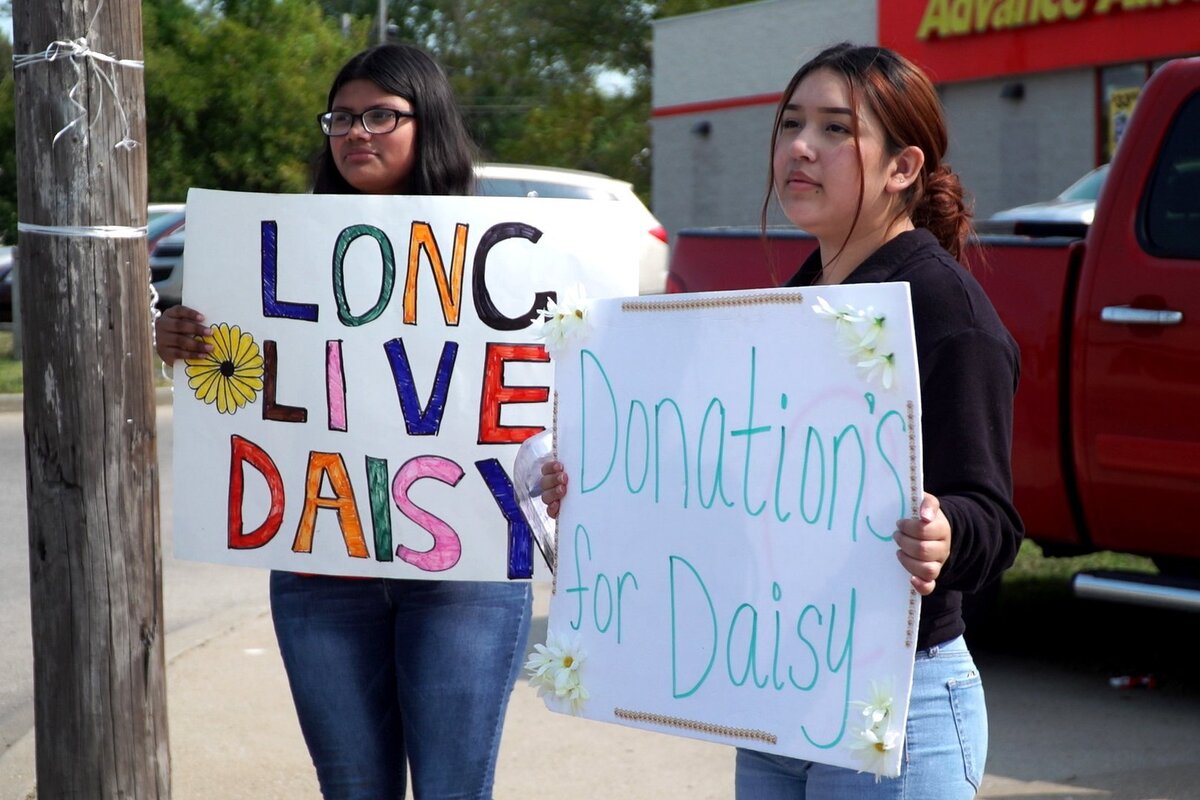 Adela Alcantar, right, and Esabella Alcantar, cousins of Daisy Martinez, hold signs outside an Advanced Auto Parts along East Truman Road in Kansas City Sunday afternoon to raise money for Daisy Martinez’s funeral. Martinez was shot and killed Wednesday night, Sep. 16, at a Mexican Independence Day celebration event on Southwest Boulevard.