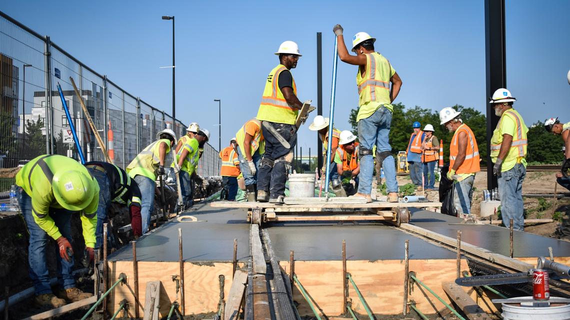 Construction workers smooth cement around newly laid streetcar tracks in Berkley Riverfront Park in July.