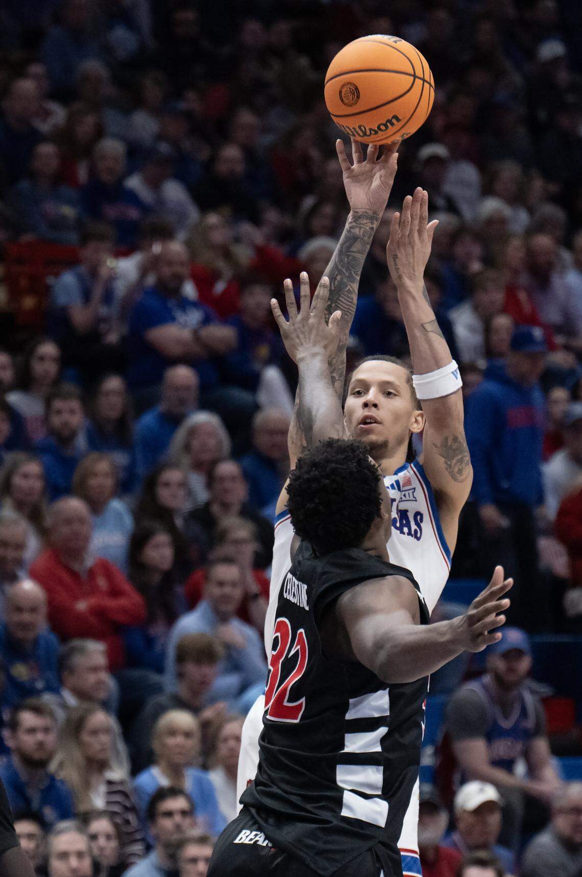 Kansas Jayhawks guard Tre White (3) shoots as Cincinnati Bearcats forward Jalen Celestine (32) blocks in the second half Allen Fieldhouse on Saturday, Feb. 21, 2026, in Lawrence, Kansas.