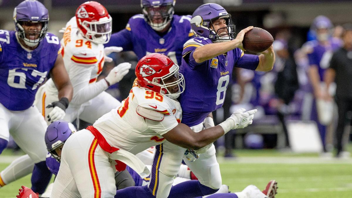 Minnesota Vikings quarterback Kirk Cousins (8) shovels the ball ahead for a completion as Kansas City Chiefs defensive tackle Chris Jones (95) tackles him during an NFL football game on Sunday, Oct. 8, 2023, at U.S. Bank Stadium in Minneapolis, Minn.