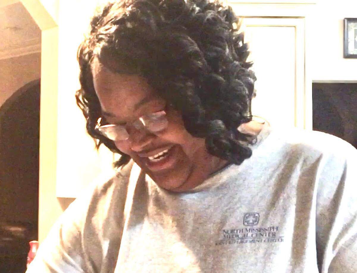 Chris Jones’ mother, Mary Woodhouse, looks through some of the mementos from Chris’ youth at the home he bought for his parents in Mississippi.